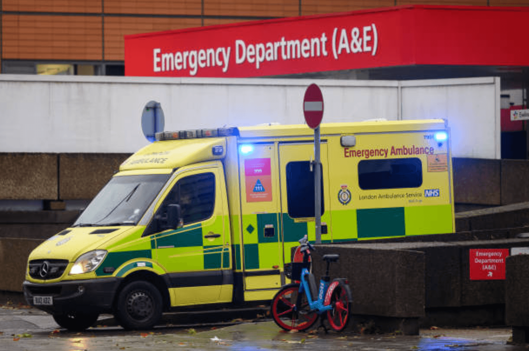 NHS Emergency Ambulance outside A&E department entrance showing increasing pressure on emergency services